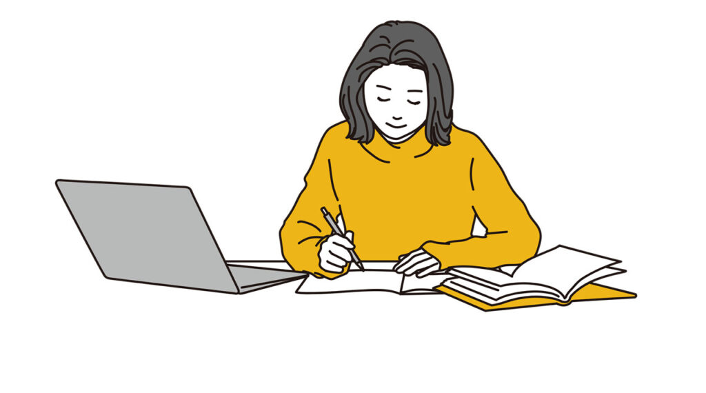 パソコンと参考書で勉強をする女性